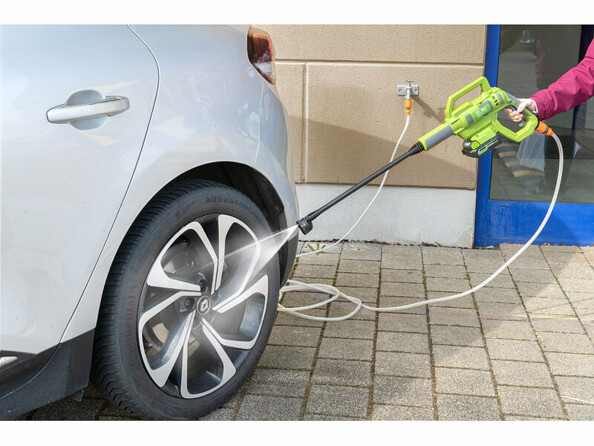 Personne tenant à une main le nettoyeur haute pression AHR-150 raccordé à un robinet et entrain de nettoyer la jante arrière gauche d'une citadine en extérieur