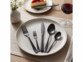 couverts de table en acier inoxydable noir mat disposés dans une assiette