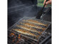 Panier à grillades en acier inoxydable mis en situation avec des sardines, posé sur un barbecue à charbon