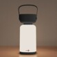 Lanterne d extérieur rechargeable LED allumée avec poignée noire sur table en bois clair