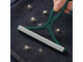 brosse anti peluche ramassant des poils sur un tapis