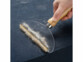 brosse anti poiles d'animaux en situtation collectant des poils sur un tapis
