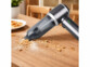 Aspirateur-souffleur à main rechargeable 25 kPa BHS-745.ak mis en situation sur une table de cuisine avec des miettes