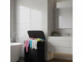 Panier à linge 150 L mis en situation dans une salle de bain avec du linge