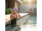 bonnet de bain en silicone sépcial cheveux long porté par une nageuse dans une piscine