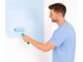 personne peignant un mur avec un petit rouleau