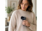 Rasoir anti-bouloche rechargeable tenu en main par une femme sur un pull