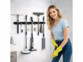 Support mural pour outils mis en situation au mur avec balais et femme portant des gants