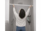 Barre télescopique 72-145 cm pour rideau de douche mise en place par une femme de dos