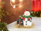 magnifique haut-parleur bluetooth aspect bonhomme de neige posée sur une table décorée pour Noël