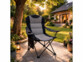 Chaise de camping pliable avec accoudoirs mise en situation dans un jardin