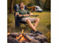 Homme en bivouac sur une chaise de camping pliable avec accoudoirs