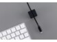 Mise en situation d'un câble lightning noir encastré dans un cube magnétique avec connecteur apparent à côté d'un clavier sans fil
