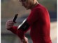 Homme en tenue de sport moulante rouge entrain de fixer l'étui de protection étanche avec téléphone sur le brassard magnétique Shapeheart