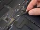 Réparation en cours d'un composant électronique miniature à l'aide d'une pince de précision antistatique ESD coloris noir