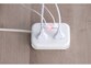 Mise en situation de la rallonge multiprise de voyage Novodio branché à une prise électrique et à quatre appareils mobiles en même temps