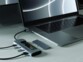 Mise en situation du hub et boîtier SSD 2 en 1 branché à un PC portable, à deux câbles USB et à deux clés USB, avec disque dur SSD installé