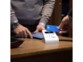 Paiement sans contact par carte sur un comptoir de restaurant via le SumUP Air et son support de chargement