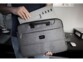 Rangement du tapis de souris multifonction dans la pochette d'une sacoche pour PC par un homme en jean et t-shirt