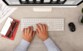 Mise en situation d'un homme en chemise entrain de taper un texte sur son clavier Cherry devant son Mac