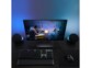 Setup gaming rétoéclairé en bleu/violet avec écran PC incurvé, souris G502 HERO, clavier QWERTY filaire, tapis de souris et deux enceintes sur bureau en bois foncé 