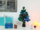 Mini sapin de Noël pos ésur une table à côté de cadeaux