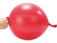 Main d'une personne tenant un ballon de frappe rouge gonflé par son élastique