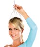 Femme blonde souriante en haut bleu tenant un masseur de tête métallique Newgen Medicals à fils