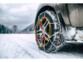 Chaîne à neige à serrage automatique montée sur une roue de voiture qui roule sur de la neige