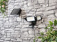 Mise en situation du projecteur LED Luminea de jour, fixé avec son panneau solaire sur un mur en pierre