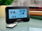 Caméra de surveillance Full HD design station météo avec détection de mouvement mise en situation sur un bureau avec sa télécommande