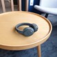 Mise en situation du casque d'écoute sans fil TEMPO Ryght coloris bleu gris posé sur une table en mois ronde moderne dans un salon contemporain