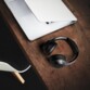 Mise en situation du casque d'écouté sans fil TIHO ANC 2 Ryght posé sur un bureau en bois foncé à côté d'un ordinateur portable blanc vue de haut