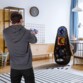 Jeune homme s'exerçant au tir avec son pistolet à fléchettes Nerf dans son salon avec la cible gonflable Nerf