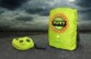 Mise en situation de la housse jaune fluo Ports Designs sur un fond gris orageux sous 2 formes : rangée dans sa pochette ou installée sur un sac à dos jusqu'à 25 L