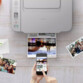 Illustration de la compatibilité smartphone et application d'impression sans fil avec impression en cours d'un document A4 imprimé sans fil à partir d'un téléphone portable tenu en main au-dessus du périphérique