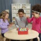 3 enfants s'amusent avec le jeu de plateau avec minuterie Perfection