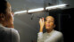 Femme quarantenaire en pull côtelé blanc se maquillant les yeux avec du phare à paupières devant le miroir à l'aide de la lampe adhésive YouniLight