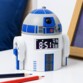 Petite figurine Star Wars D2-R2 avec écran numérique affichant 8:51 posée sur un meuble laqué blanc à côté d'une ardoise à craie et deux crayons de couleurs