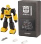 Robot programmable Bumblebee G1 Performance Robosen avec boîte de rangement grise au logo Transformers, câble de chargement USB, chargeur secteur et blaster en accessoires