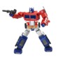 Jouet robot miniature Optimus Prime Elite 1ère Génération avec les jambes écartées et le blaster noir en accessoire pointé vers la droite