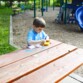 Enfant utilise un spirographe sur un table extérieure