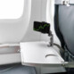 Support réglable et orientable fixé à la tablette d'un siège passage d'un avion avec smartphone affichant des courbes de trading rouges et vertes à l'horizontale