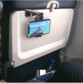 Mise en situation du support de voyage universel pour smartphone accroché à la tablette arrière d'un siège d'avion et à un téléphone portable avec écran allumé
