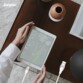 Mise en situation du câble Lightning en cours de branchement à un iPad posé sur un bureau par une personne le tenant par les coins