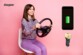 Femme souriante se tenant sur une chaise un volant dans les mains pour faire semblant de conduire avec logo Energizer, chargeur allume-cigare et indication du niveau de charge d'une batterie
