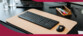 Mise en situation du clavier Cherry coloris noir dans un setup de bureau avec écran PC, souris de la même couleur et tapis de bureau saumon