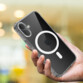iPhone 16 noir avec étui de protection transparent tenu en main par une personne en extérieur