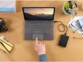 Utilisation du disque dur externe Seagate Expansion branché au port USB d'un PC portable sur lequel une personne travail sur un bureau à côté d'objets divers et variés