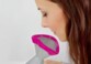 Zoom sur le visage d'une femme brune posé devant l'ouverture naso-buccale avec embout en silicone rose de l'inhalateur